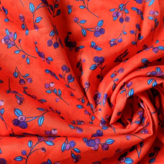 tissu popeline de coton baies sur fond rouge orangé