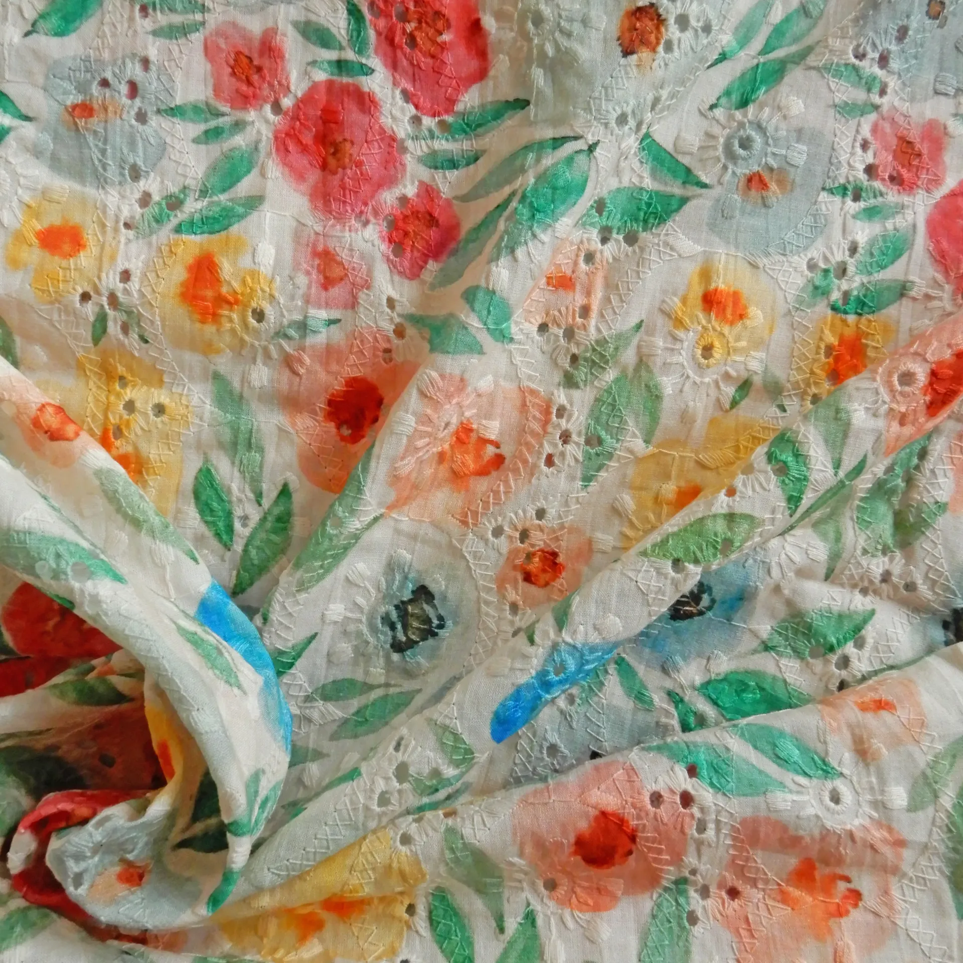 Fleurs multicolores imprimées sur un tissu brodé écru