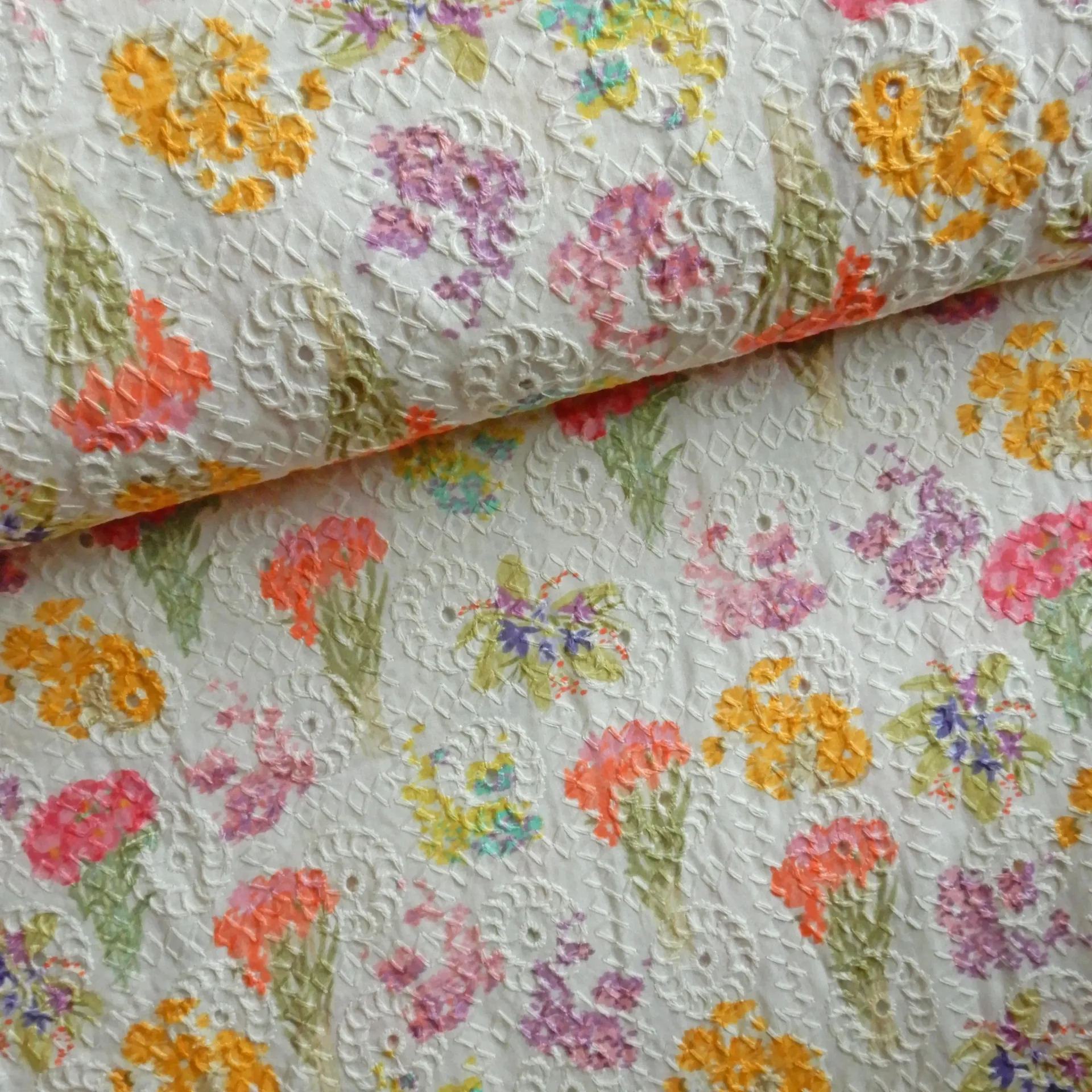 Bouquets de fleurs imprimés sur un tissu brodé écru