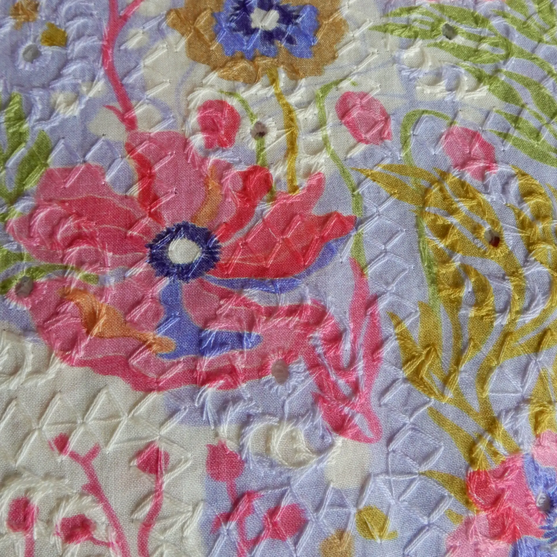 Coquelicots roses imprimés sur un tissu brodé bleu